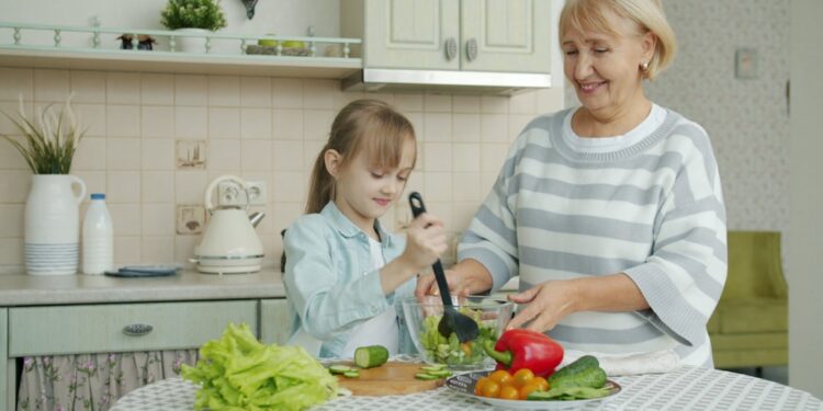 woman-cooking-salad-unsplash - GUSTOwebzine A woman carefully dressing chilled grain salads in a bright kitchen, showcasing global culinary technique