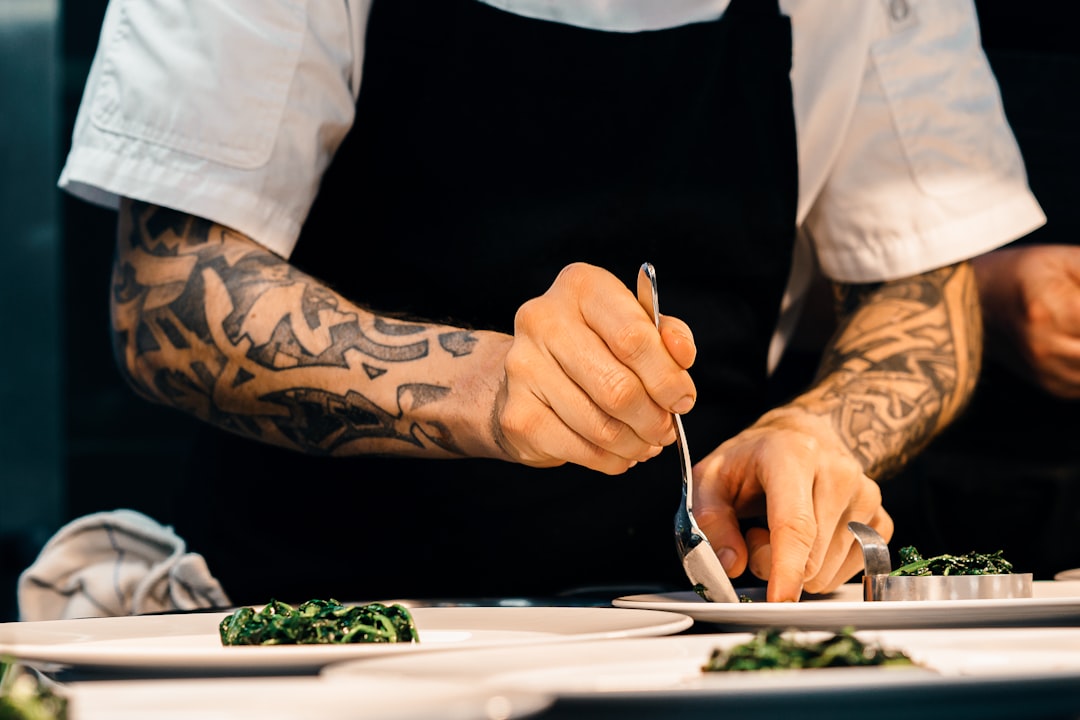 Un giovane chef impiatta un piatto a una competizione culinaria, rappresentando la prossima generazione di talenti che guida il futuro
