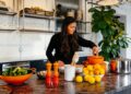 a woman arranges roasted root vegetables on a plate as part of the new autumn menus service in a kitchen.
