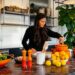 a woman arranges roasted root vegetables on a plate as part of the new autumn menus service in a kitchen.