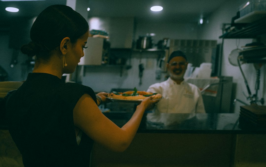 Ein Koch und ein Mitglied des Front-of-House-Personals besprechen gemeinsam Zutaten-Details, bevor der Hotelservice beginnt