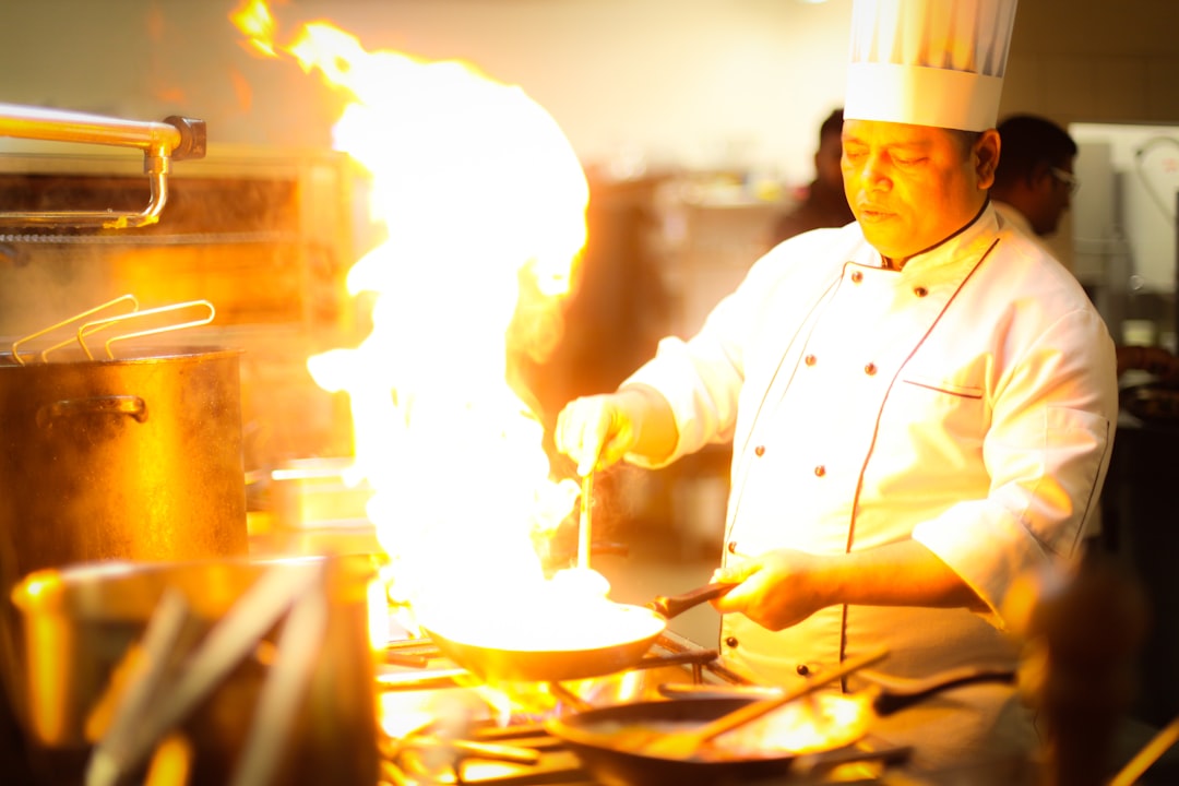 Een kok demonstreert een ambachtelijke culinaire techniek in een hotelkeuken als onderdeel van een bestemmingsgericht eetprogramma