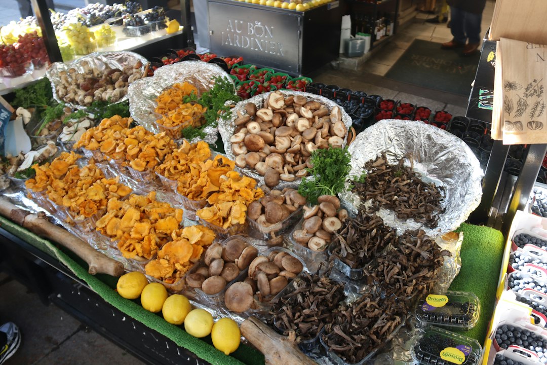 Een chef-kok onderzoekt paddenstoelen op de oogstmarkt, een reflectie van de seizoensproducten die beschikbaar zijn voor thuiskoks in Europa en Azië.