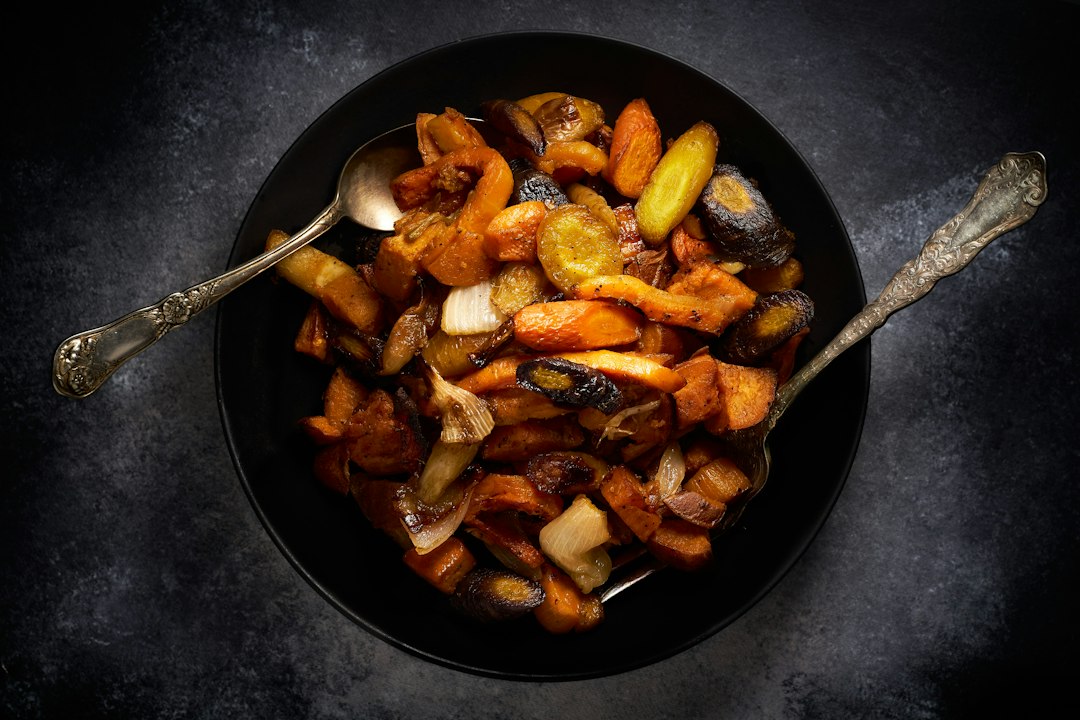 A chef arranging roasted roots and warm grain in a ceramic bowl for an elegant seasonal dinner