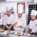 A chef presents a plate at an international culinary congress, like San Sebastian Gastronomika.
