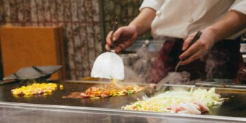 chef-roostert-groenten-unsplash - GUSTOwebzine Een chef-kok roostert seizoensgebonden wortelgroenten in een professionele keuken tijdens de herfstequinox, waarbij hij klassieke technieken demonstreert
