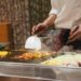 chef-roostert-groenten-unsplash - GUSTOwebzine Een chef-kok roostert seizoensgebonden wortelgroenten in een professionele keuken tijdens de herfstequinox, waarbij hij klassieke technieken demonstreert