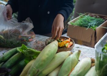 Een hotelchef selecteert seizoensgebonden producten op een lokale markt, wat de waarden van cultureel verankerde eetprogramma's weerspiegelt
