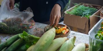 Een hotelchef selecteert seizoensgebonden producten op een lokale markt, wat de waarden van cultureel verankerde eetprogramma's weerspiegelt