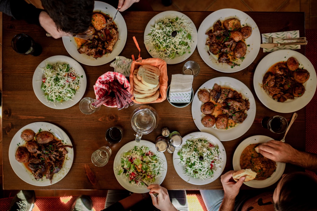 Een gezin dat aan een eettafel zit met verschillende flessen wereldse smaakmakers in het midden