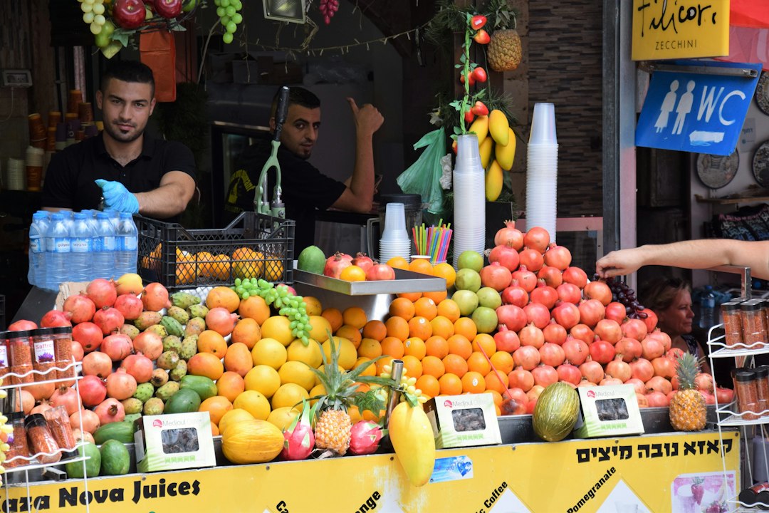 A man samples a pressed juice drink at an outdoor orchard market during early autumn