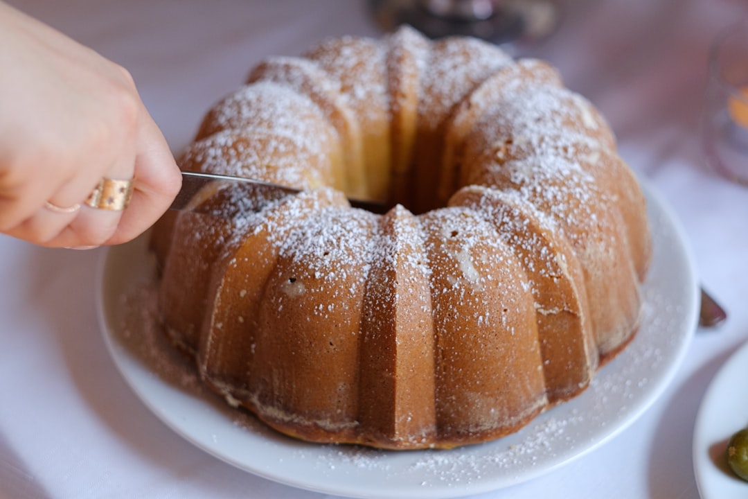 Een persoon snijdt een gekruide peren- en walnotencake aan als onderdeel van een serie herfstgerechten die het bakken in het oogstseizoen viert