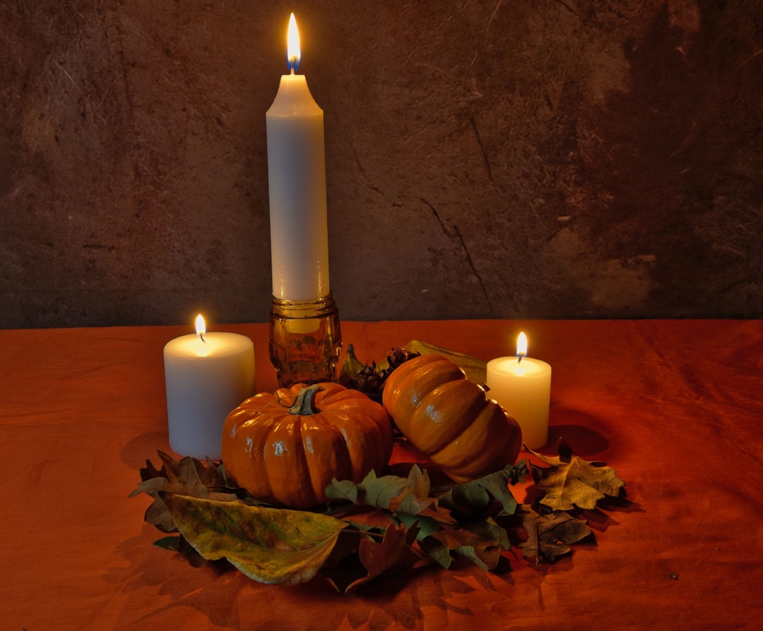 A server adjusts candlelit table settings in a cosy dining room prepared to welcome guests for the autumn menus season.
