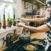 A home cook carefully stirring a warm grain dish in a large pot, surrounded by seasonal root vegetables on a kitchen counter