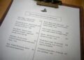 Chef calculating menu pricing for a new dish in a professional kitchen