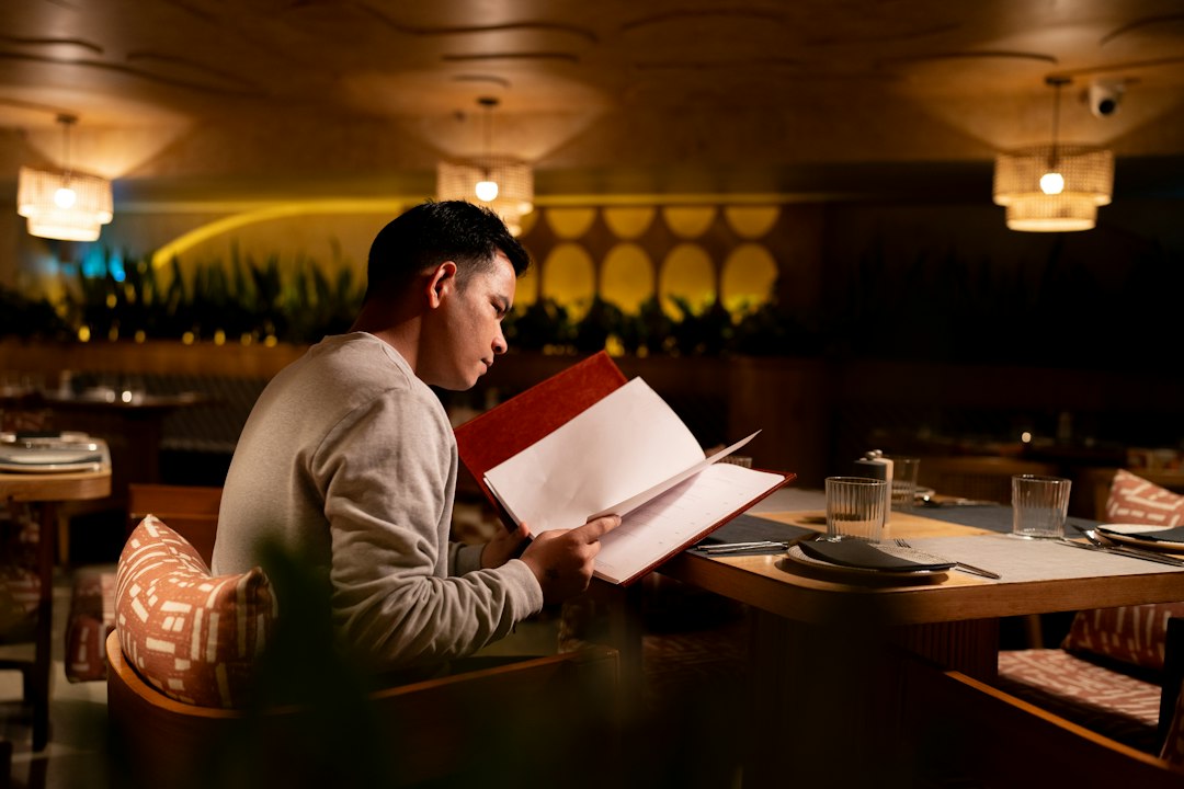 Restaurant manager checking menu pricing figures against a printed menu