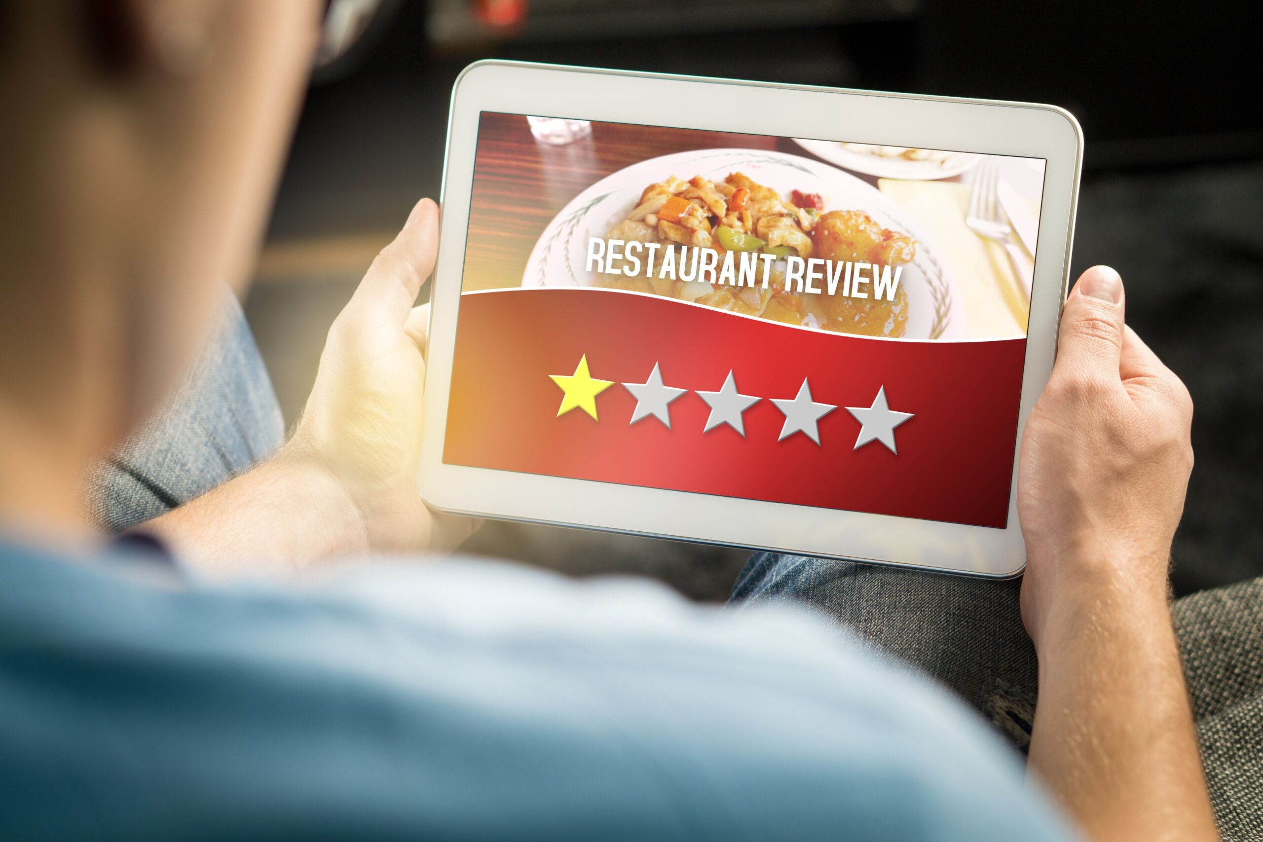 Restaurant professional using tablet to collect customer feedback and prevent negative reviews