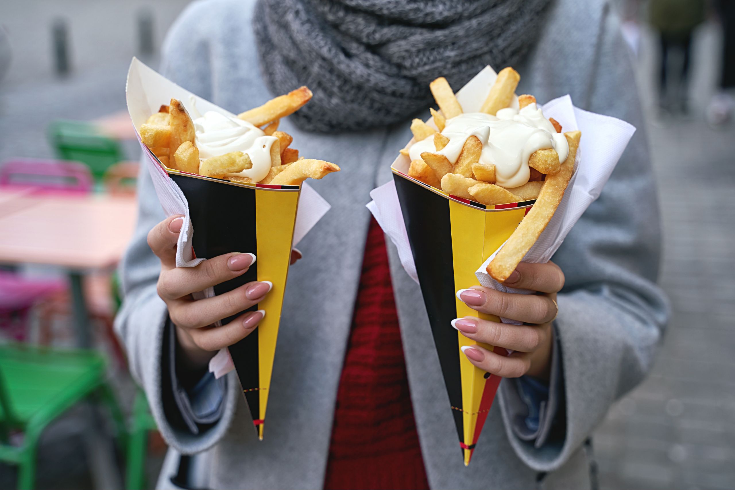 jovem com 2 cones de batata frita belga com maionese gusto webzine