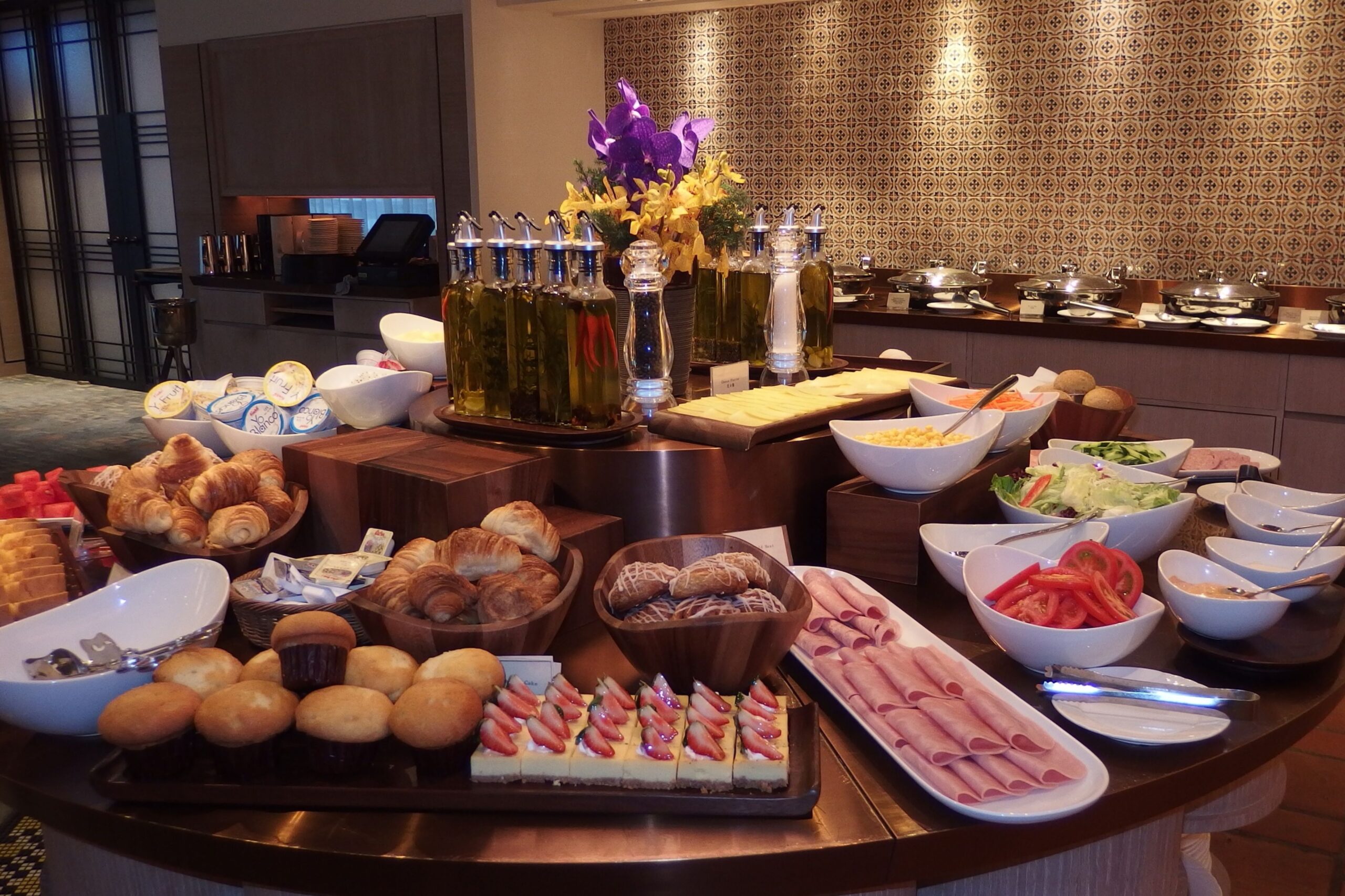 Buffet della colazione in hotel con frutta fresca, pasticcini e piatti caldi in un ambiente di ristorante di lusso