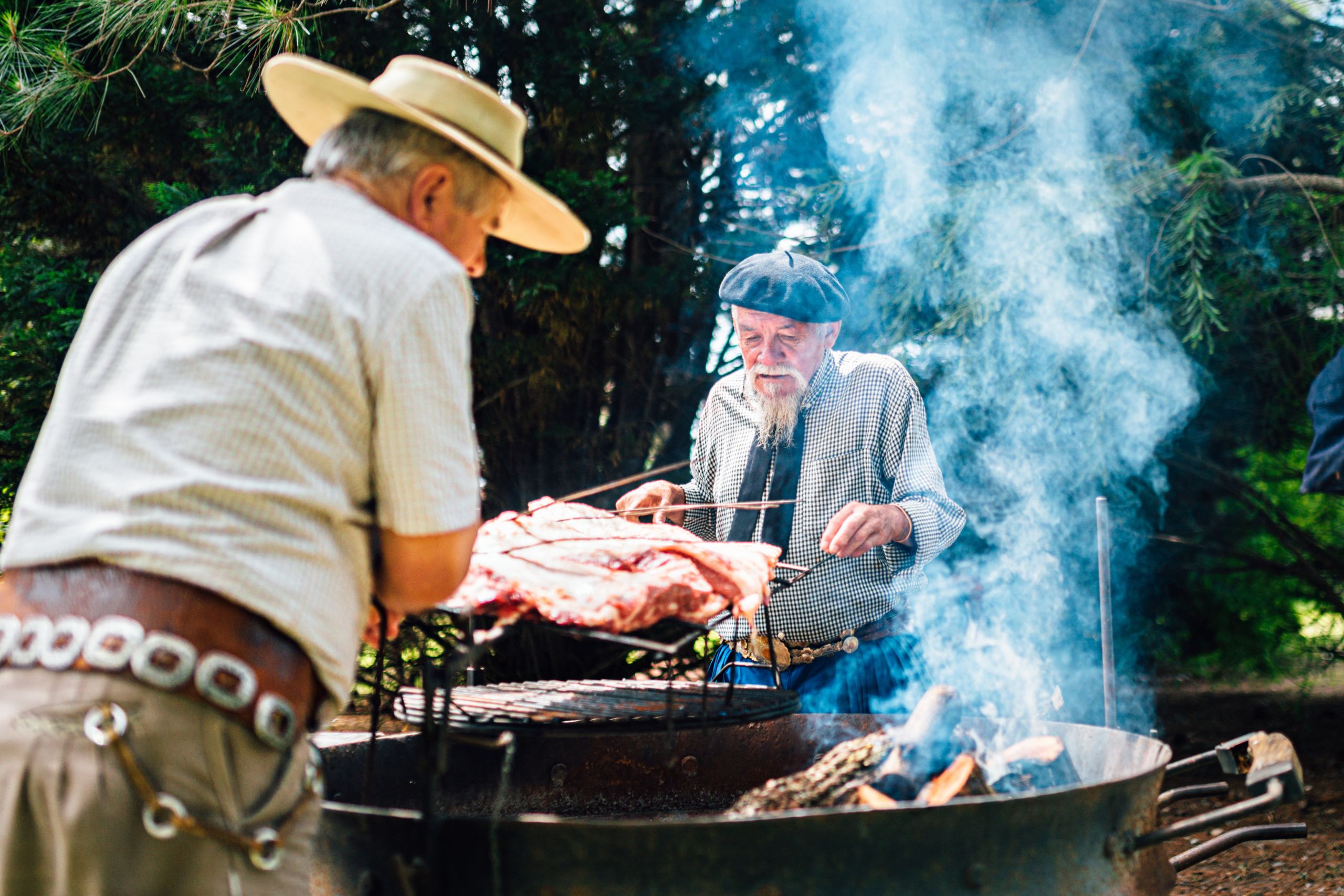 Tradizionale grigliata di carne asado uruguayano sulla parrilla con fumo e fiamme