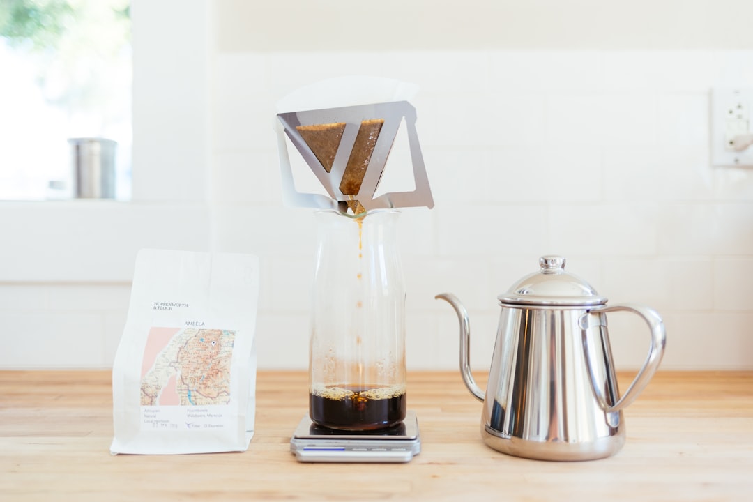 Um barista despejando cuidadosamente água quente sobre grãos de café de origem única em um gotejador de café em um café especializado