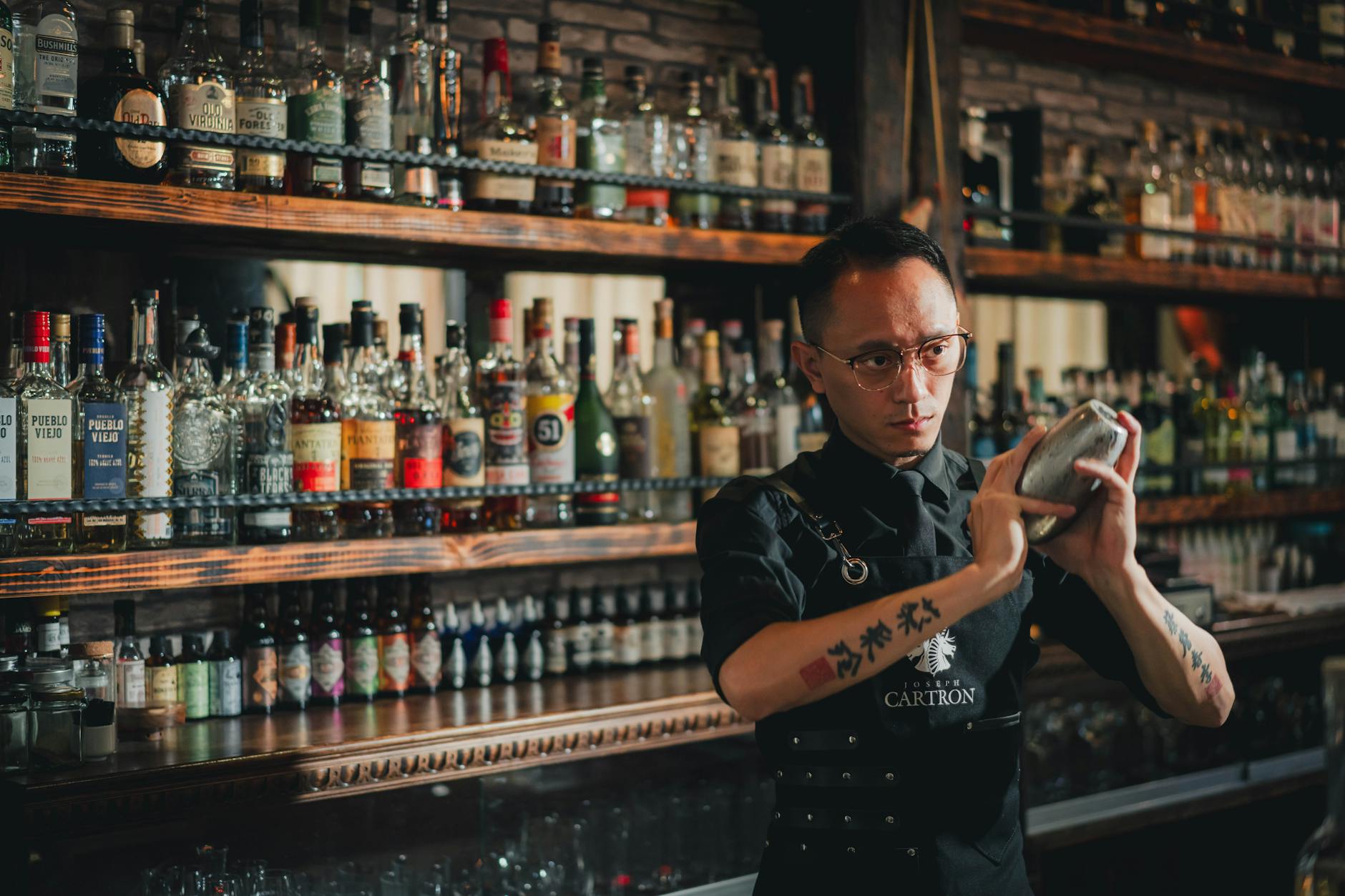 Um bartender habilidoso demonstrando técnicas de mixologia enquanto prepara um coquetel artesanal no bar de um restaurante