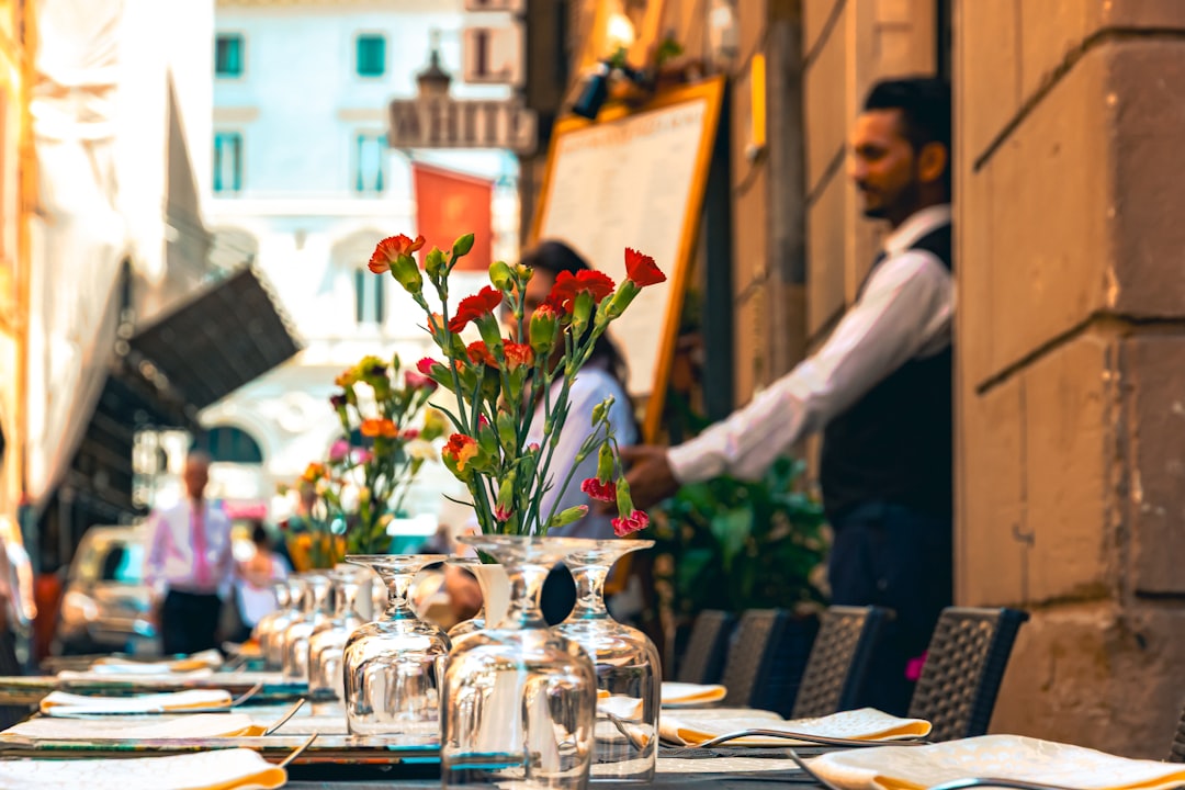 Un chef dresse une table sur la terrasse d'un restaurant en préparation du service en terrasse d'été au début de la saison extérieure.