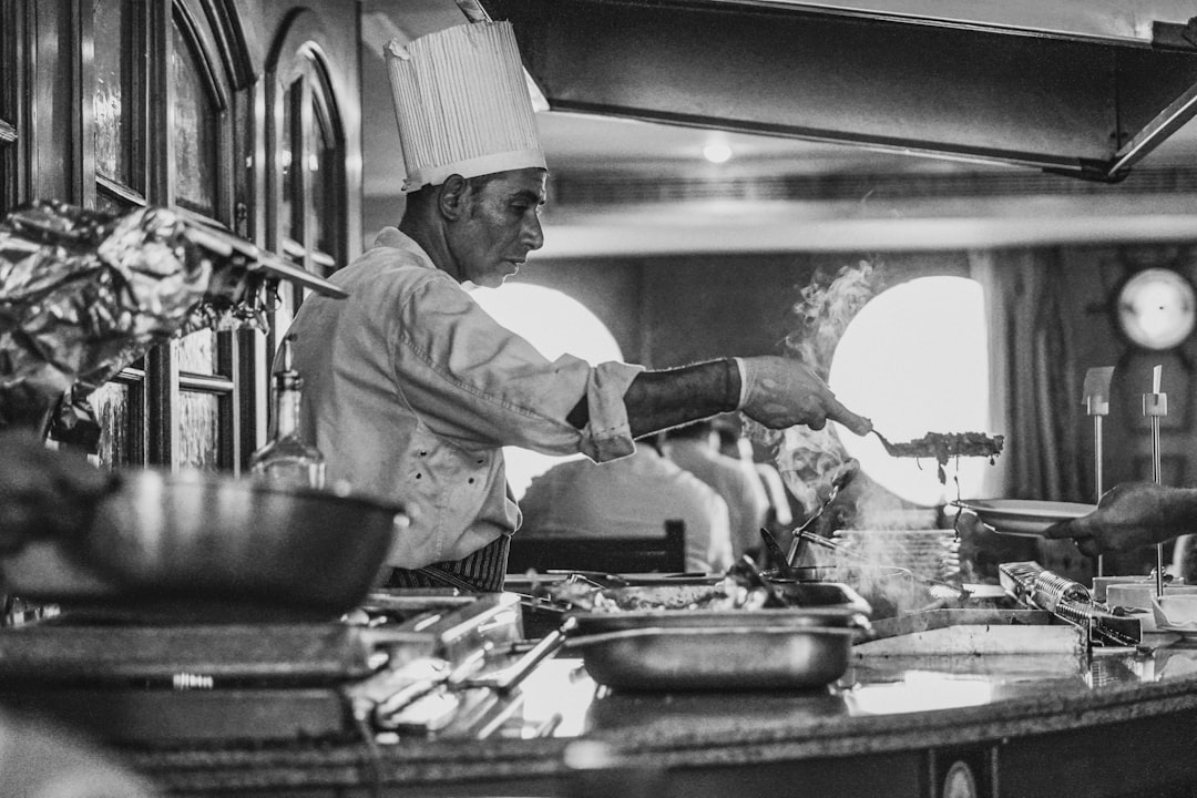 Un chef professionnel remue un grand pot de ragù napolitain sur un feu doux dans une cuisine traditionnelle