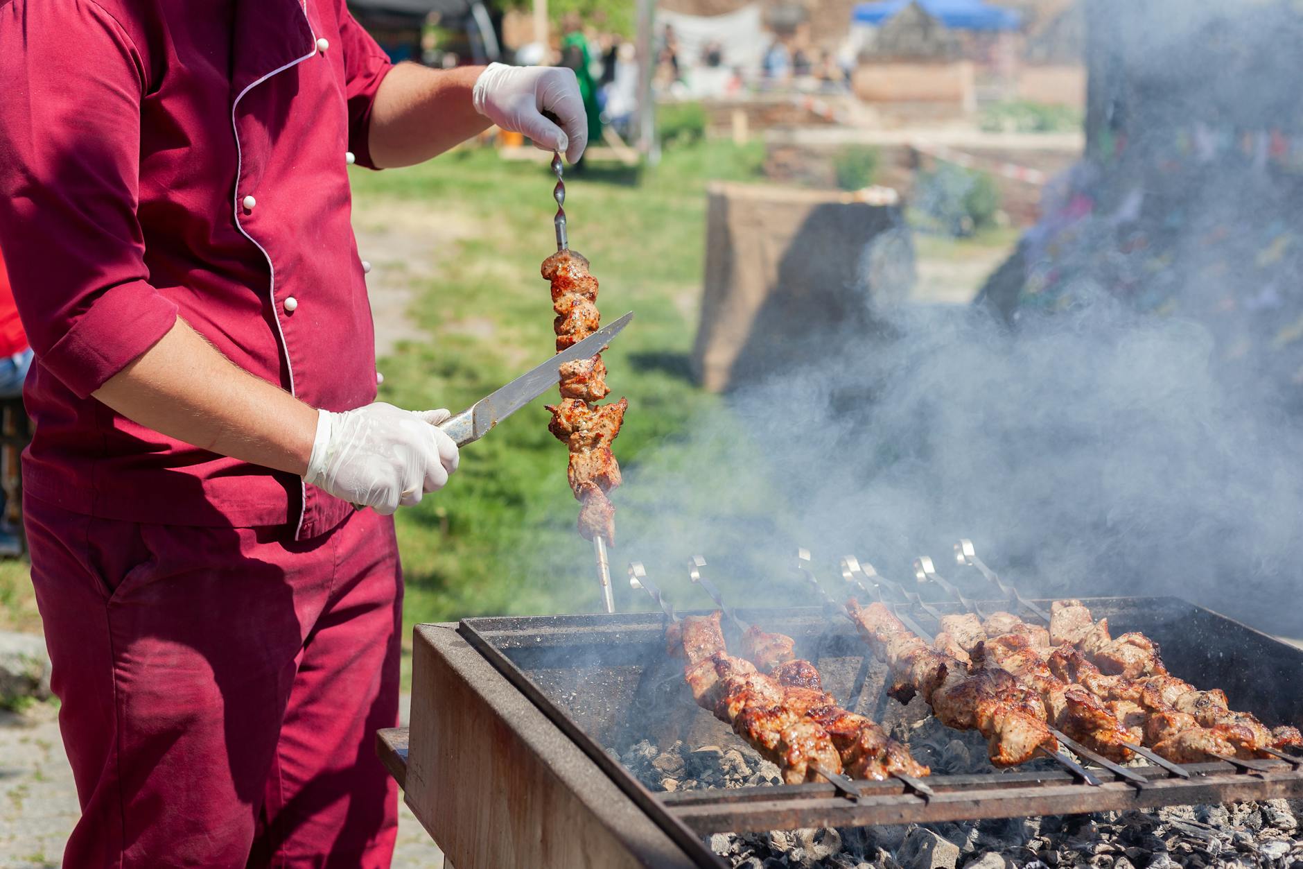 Un chef professionnel prépare les plats de service à une station de restauration en plein air lors d'un grand événement hors site.
