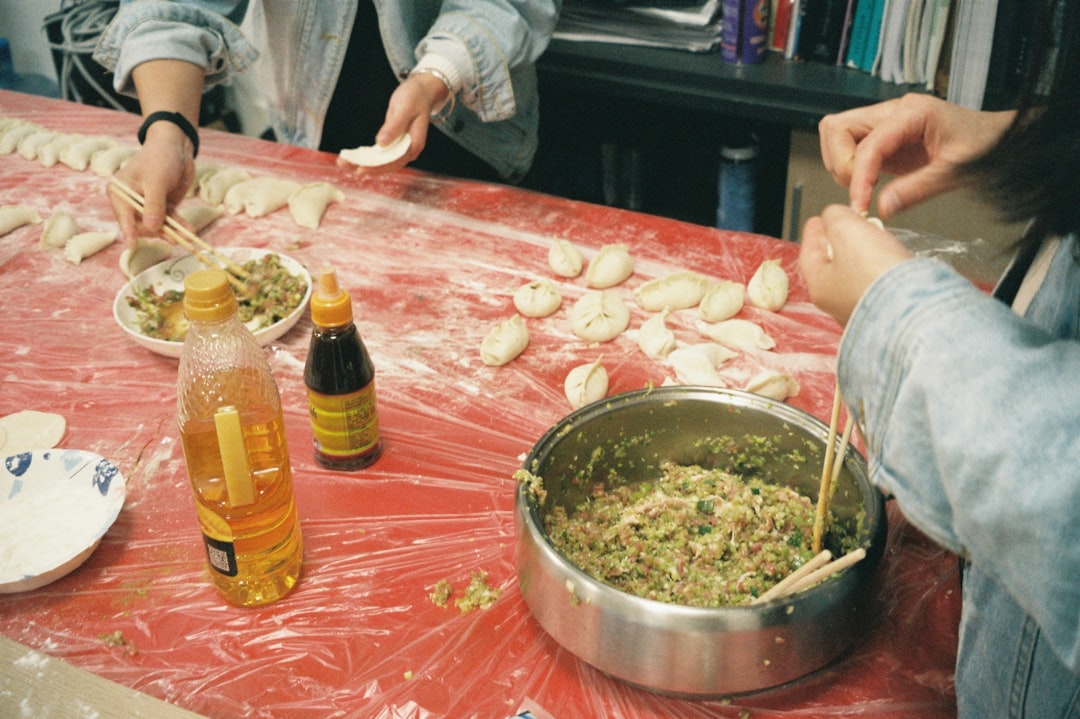 Une femme pliant des raviolis faits à la main sur une surface en bois fariné, démontrant l'art traditionnel derrière ce plat bien-aimé