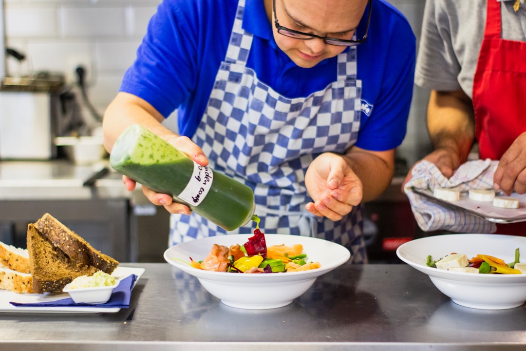 Un chef versa con cura le zuppe fredde in una ciotola bianca in una cucina professionale