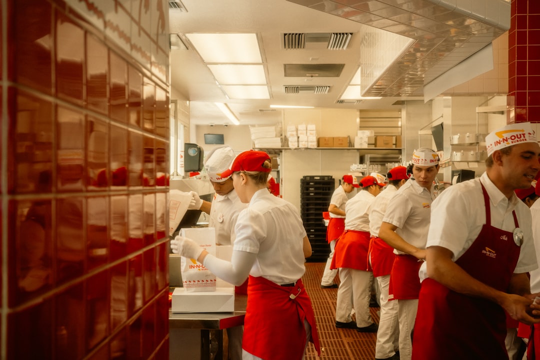 Un serveur d'hôtel guide un client à travers un plat inconnu pendant la formation du personnel pour les cuisines du monde à une table de fine dining