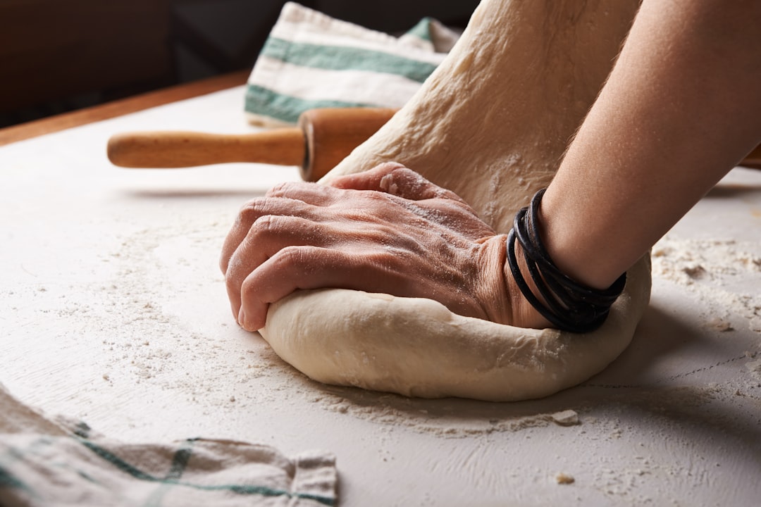 Un fornaio esperto che modella una pagnotta a lievitazione naturale a mano, riflettendo l'artigianato al centro delle tradizioni globali del pane