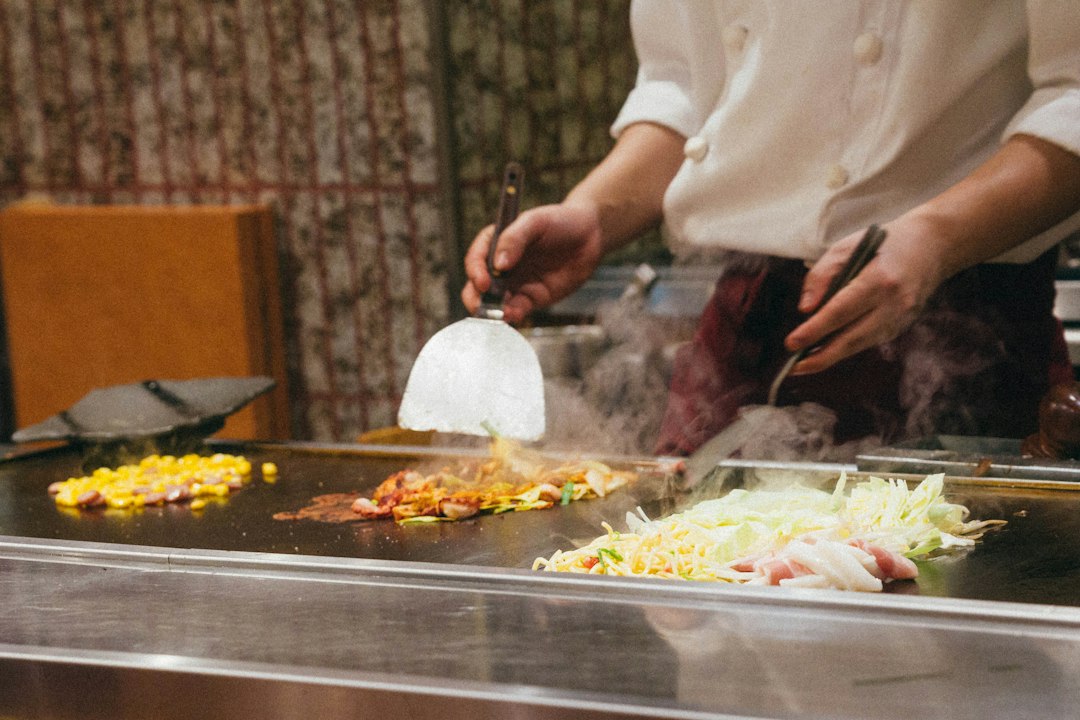 Uno chef arrostisce radici stagionali in una cucina professionale all'equinozio d'autunno, dimostrando tecniche classiche