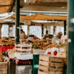 Um produtor indígena exibe legumes tradicionais numa banca de mercado, representando o espírito da Terra Madre.