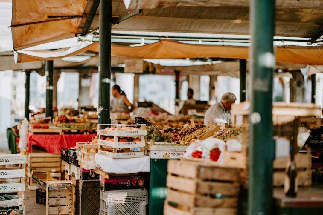Um produtor indígena exibe legumes tradicionais numa banca de mercado, representando o espírito da Terra Madre.