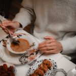 Uma pessoa provando o tempero de uma colher de pau enquanto cozinha um prato global desconhecido na cozinha de um restaurante.