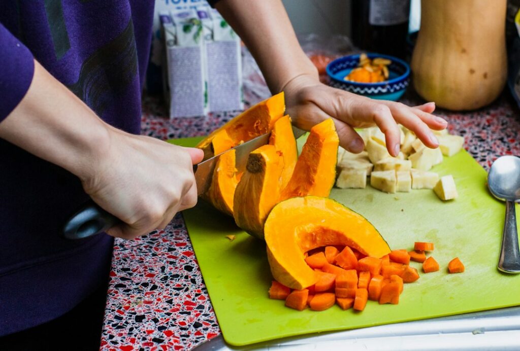 Chef mexendo uma panela de base de sopa de abóbora no fogão